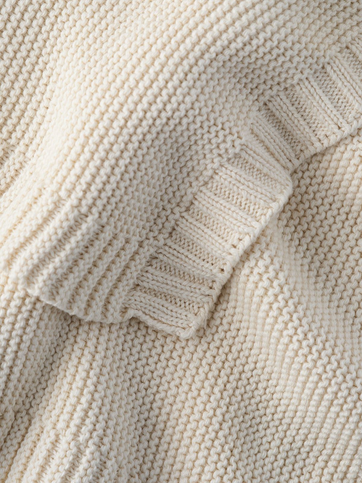 Close-up of a Cream knitted blanket and its ribbed edge