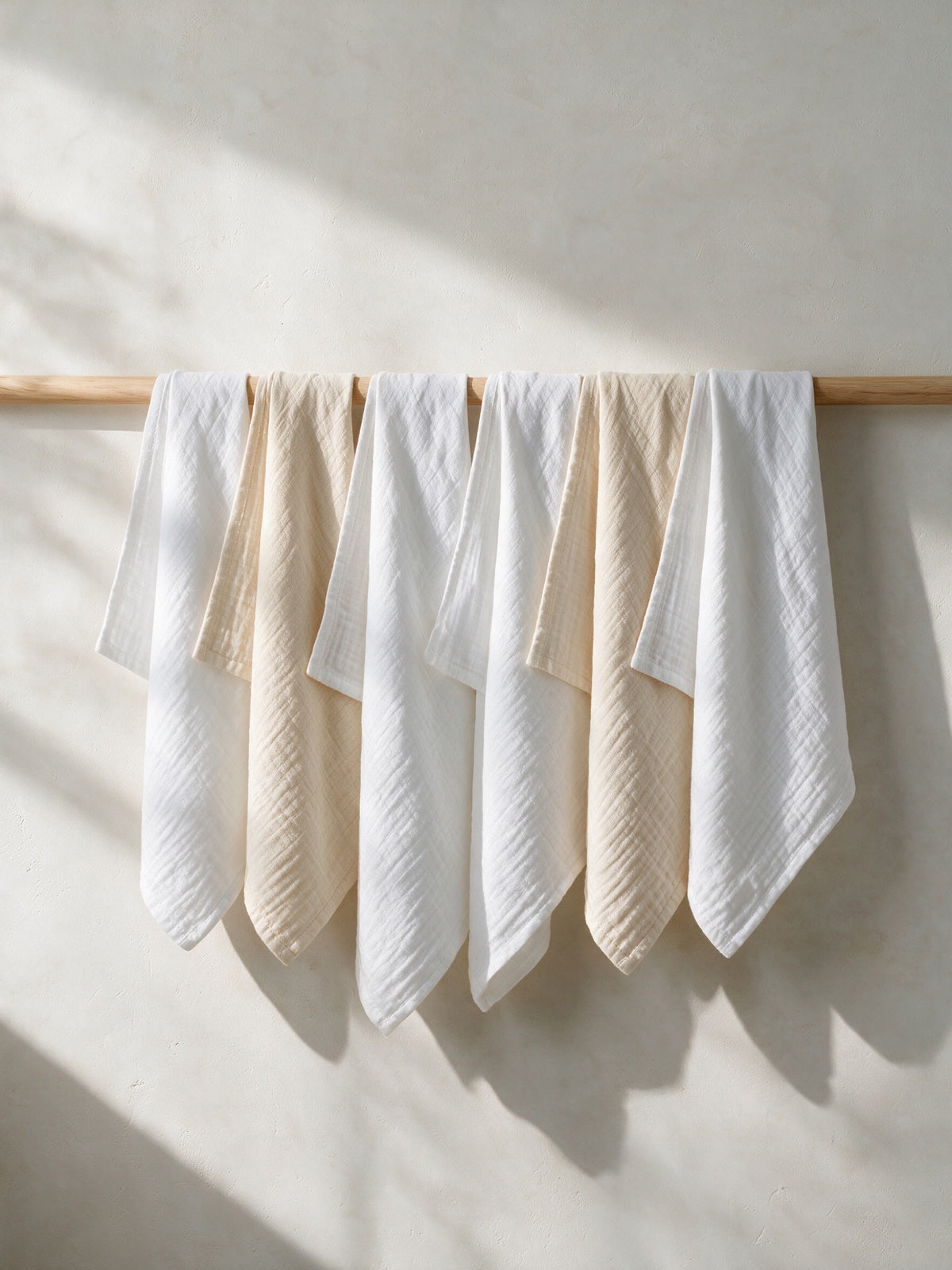 Cloud Nine muslin squares hanging on a wooden rail